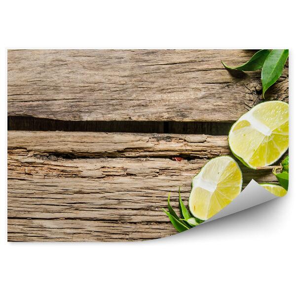 Fototapeta na zeď Zelené plátky limetky rozpůlené listy dřevo