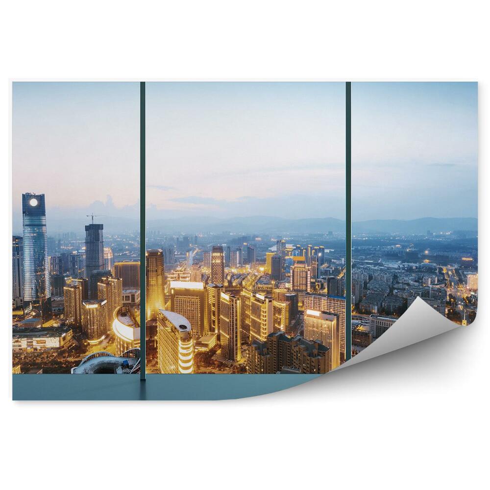 Samolepící fototapeta Soumrakem osvětlené město pohled shora přes okno